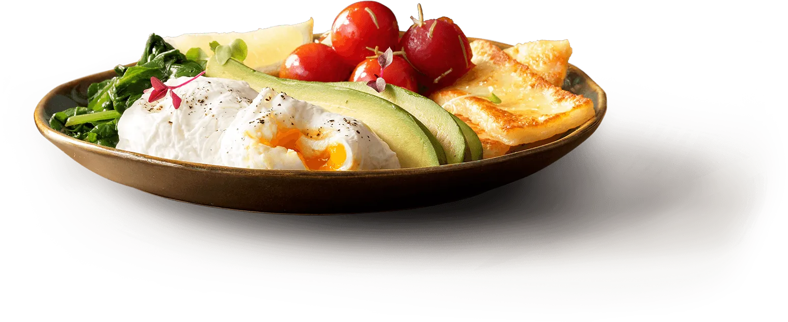 Low-carb breakfast plate with eggs, avocado, bacon, tomatoes, and spinach