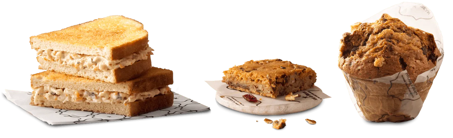 A toasted sandwich, a sweet treat and huge muffin on a white background