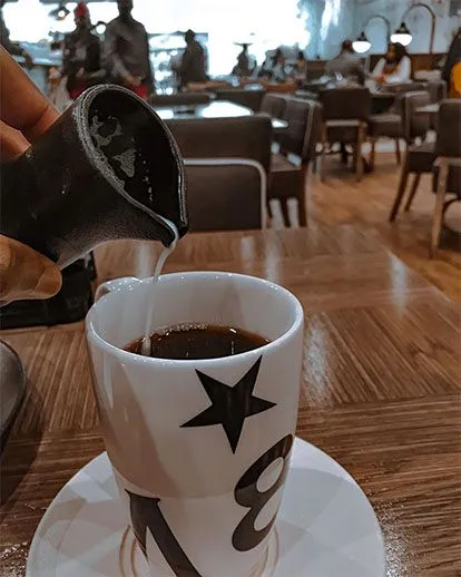 Pouring milk into coffee mug